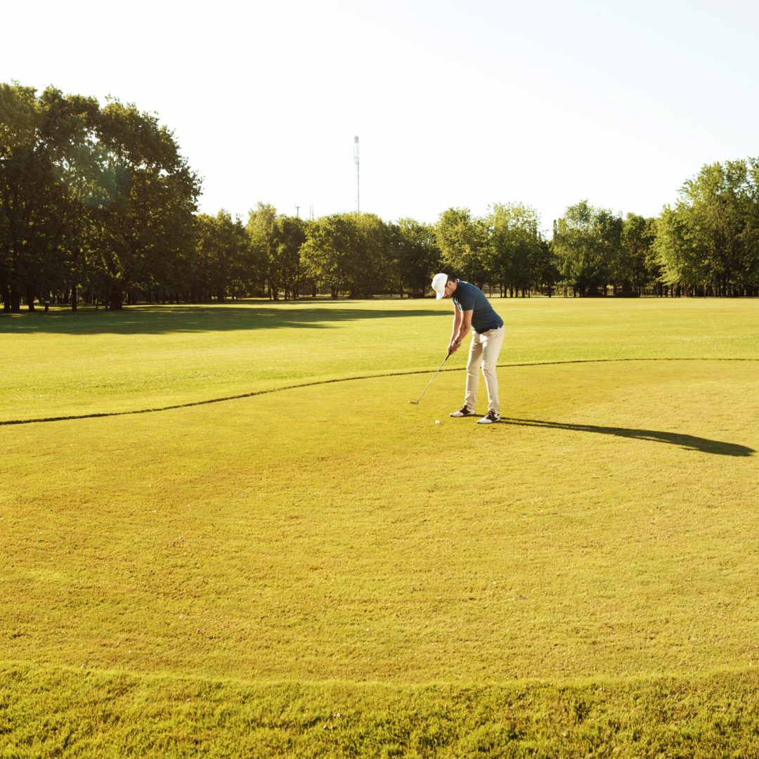 young sportsman practicing golf with his teacher